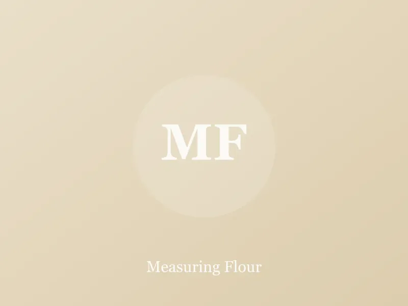 Flour being spooned into a measuring cup and leveled with a knife